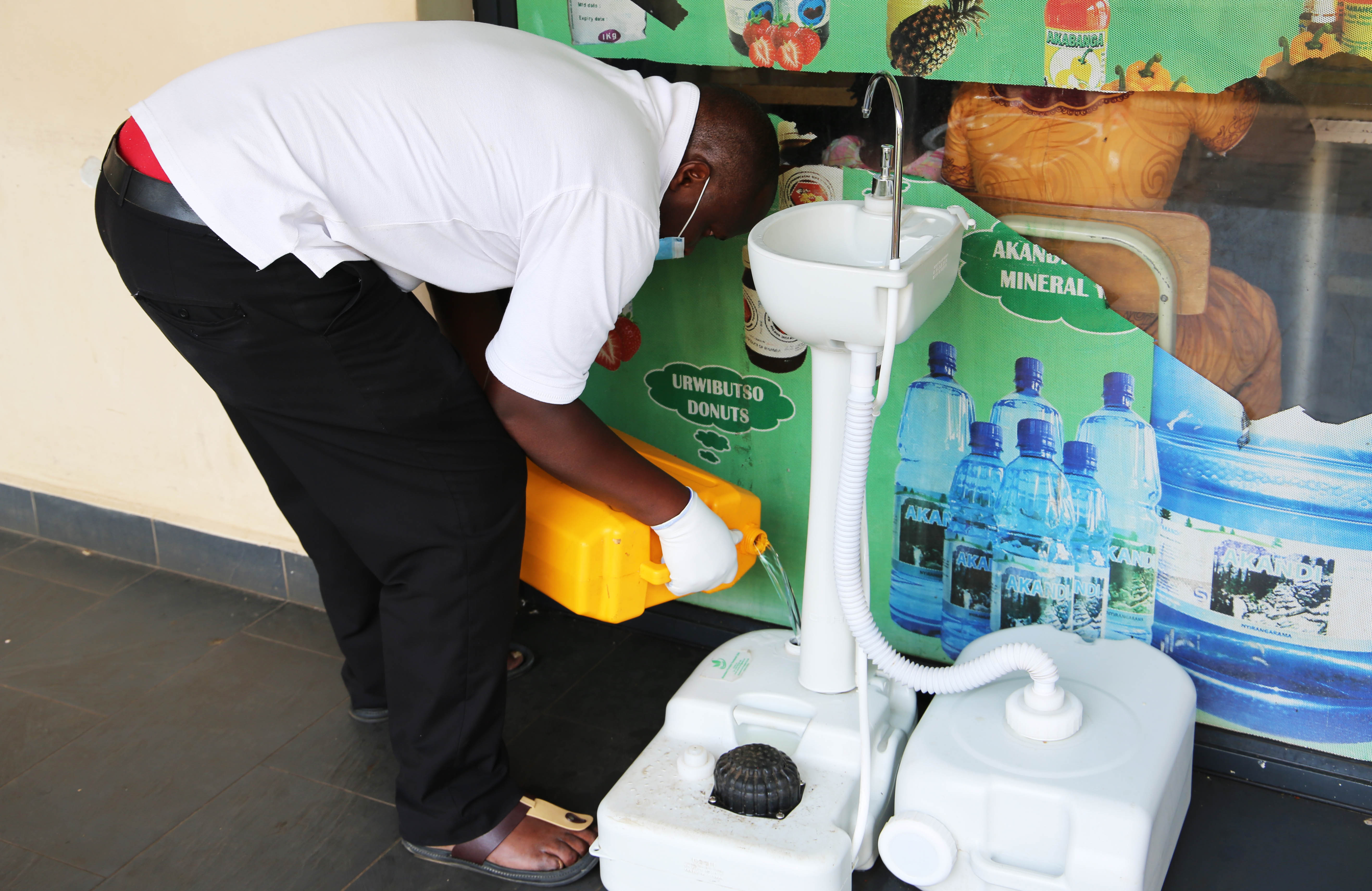 A mobile money agent and his clients wear facemasks in Kigali yesterday (Craish Bahizi)