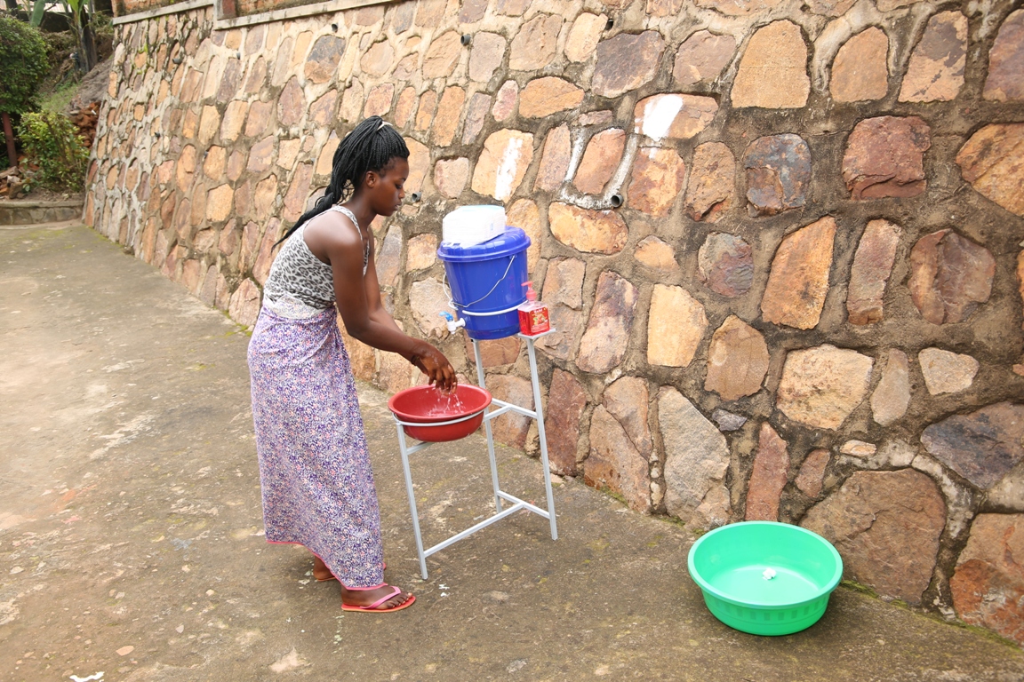 A lady washing her hands before stepping back home from a Boutique/Craish Bahizi 