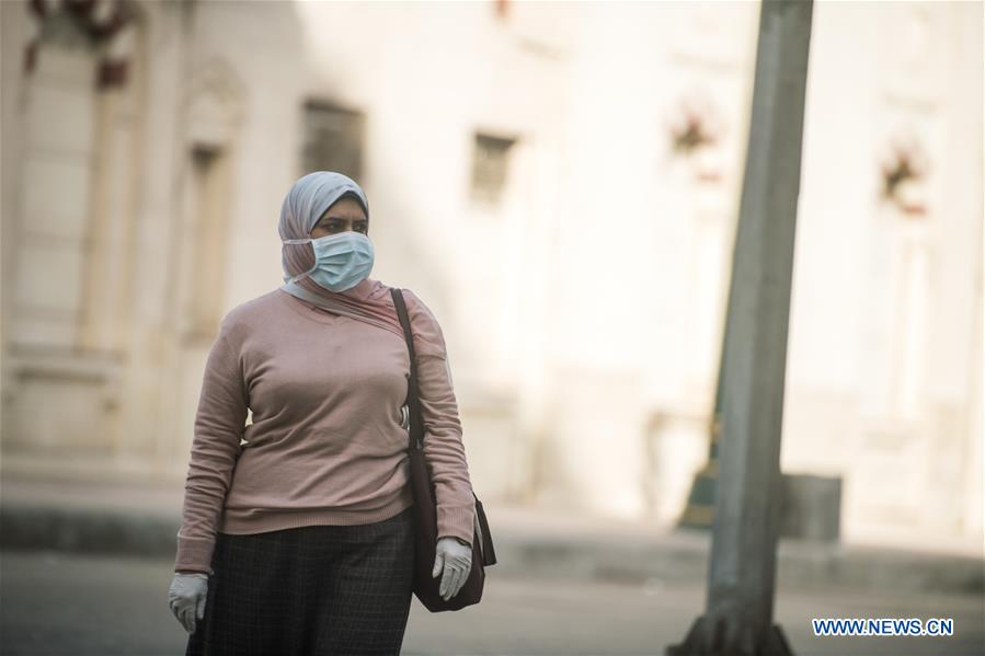 A woman wearing a face mask is seen in a street of Cairo, Egypt, on March 22, 2020. Egypt confirmed on Sunday 33 new COVID-19 cases, raising the total cases in the country to 327, the Egyptian Health Ministry said in a statement. 