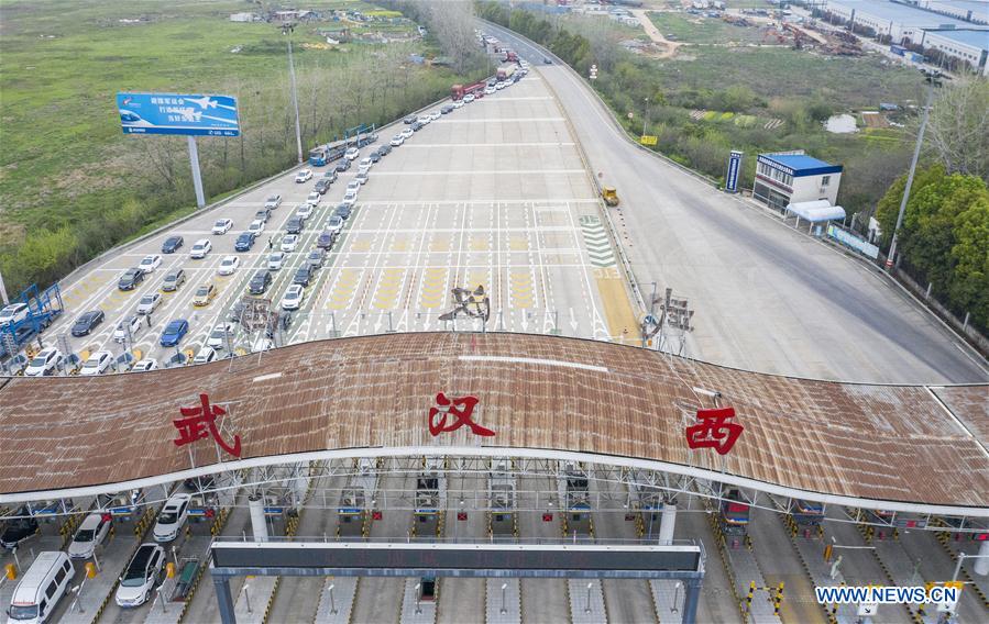 Aerial photo taken on March 24, 2020 shows vehicles back to Wuhan wait to pass through a highway toll station in Wuhan, central China's Hubei Province. 