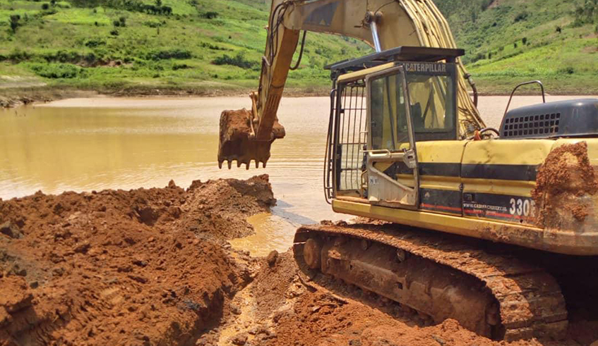 An excavator machine exavates a way out for the water in the dam (Courtesy photo)
