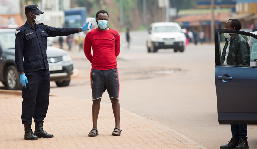 A Rwanda National Police Officer measures temperatures levels of road users. Traffic Police introduced the fever testing exercise for motorists and pedestrians on Sunday, March 30, in an effort to fight the coronavirus pandemic.  / Dan Nsengiyumva  