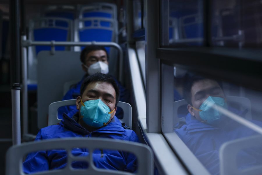 Yuan Weifang (front), an experienced ICU nurse from Shanghai Seventh People's Hospital, takes a nap on the bus back to hotel in Wuhan, central China's Hubei Province, April 1, 2020. 