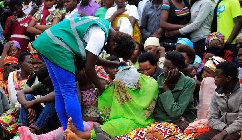 A volunteer helps a trauma victim during a past event to commemorate the 1994 Genocide against the Tutsi at Murambi Genocide Memorial in Nyamagabe District. / Photo: Sam Ngendahimana.