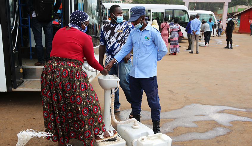 Passengers wash hands before boarding a bus at Nyabugogo Taxi Park in Kigali on Monday./ Craish Bahizi
