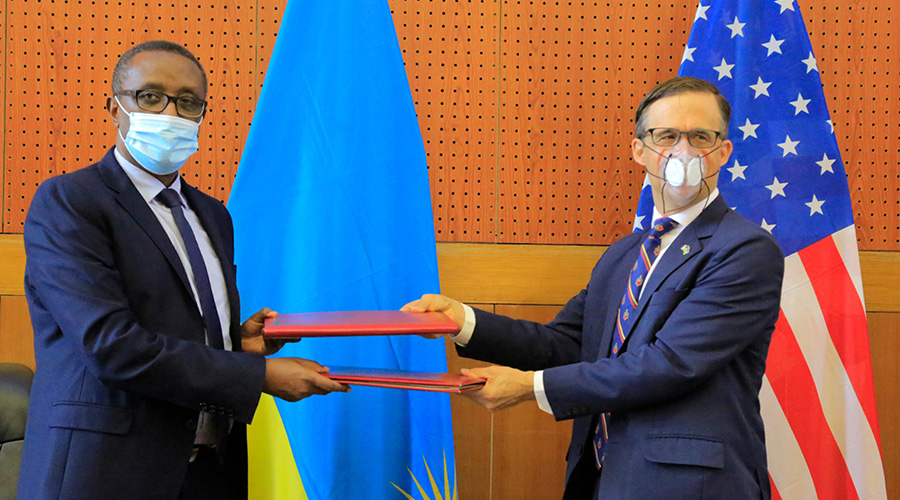 Foreign Affairs Minister Dr Vincent Biruta and US Ambassador Peter Vrooman exchange documents after signing a Status of Force Agreement (SOFA) to strengthen military cooperation between the two countries. The agreement was signed in Kigali on Thursday, May 28. / Photo: Courtesy