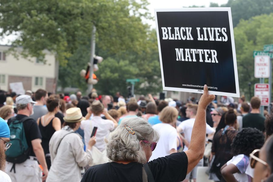 A woman holds up a Black Lives Matter sign at the Michael Brown memorial in Ferguson, Missouri, U.S., on August 9, 2015. 
