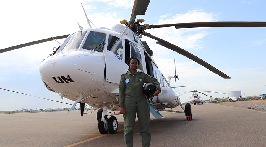 Lt Ariane Mwiza, the  young RDF pilot currently with the United Nations Mission in South Sudan, stands next to a UN peacekeepers helicopter. / Courtesy