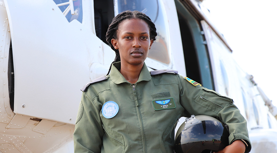Lt Ariane Mwiza, the  young RDF pilot currently with the United Nations Mission in South Sudan, stands next to a UN peacekeepers helicopter. / Courtesy