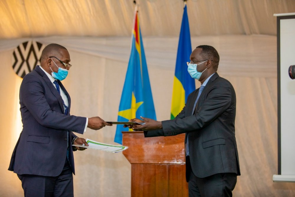 Health minister Dr Daniel Ngamije (right) exchanges documents containing the meeting resolutions with DR Congo's deputy minister for internal Affairs Innocent Bokele Walaka. 
