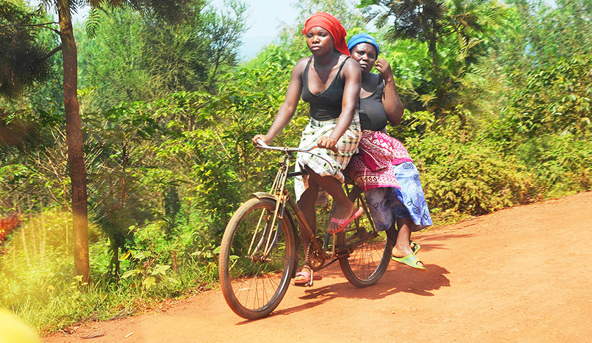 Two women use a bicycle as a means of transport in Ruhuha Sector, Bugesera District. Bicycle is regarded as an affordable, reliable, clean and environmentally friendly means of transportation.