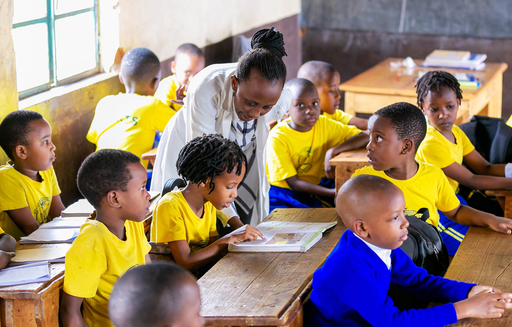 A teacher helps students during an exercise in 20 February 2020 .Teachers in private schools are complaining of having been laid off by their employers after government closed schools until September. 