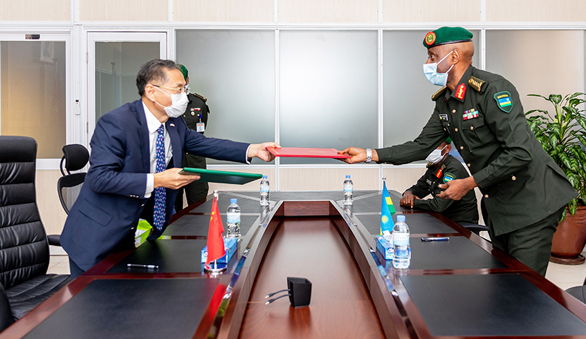 Gen. Jean Bosco Kazura, RDF Chief of Defence Staff (right), and Amb. Rao Hongwei, the Chinese envoy to Rwanda, exchange documents after signing the handover in Kigali on Wednesday, June 3. / Photos: Gad Nshimiyimana