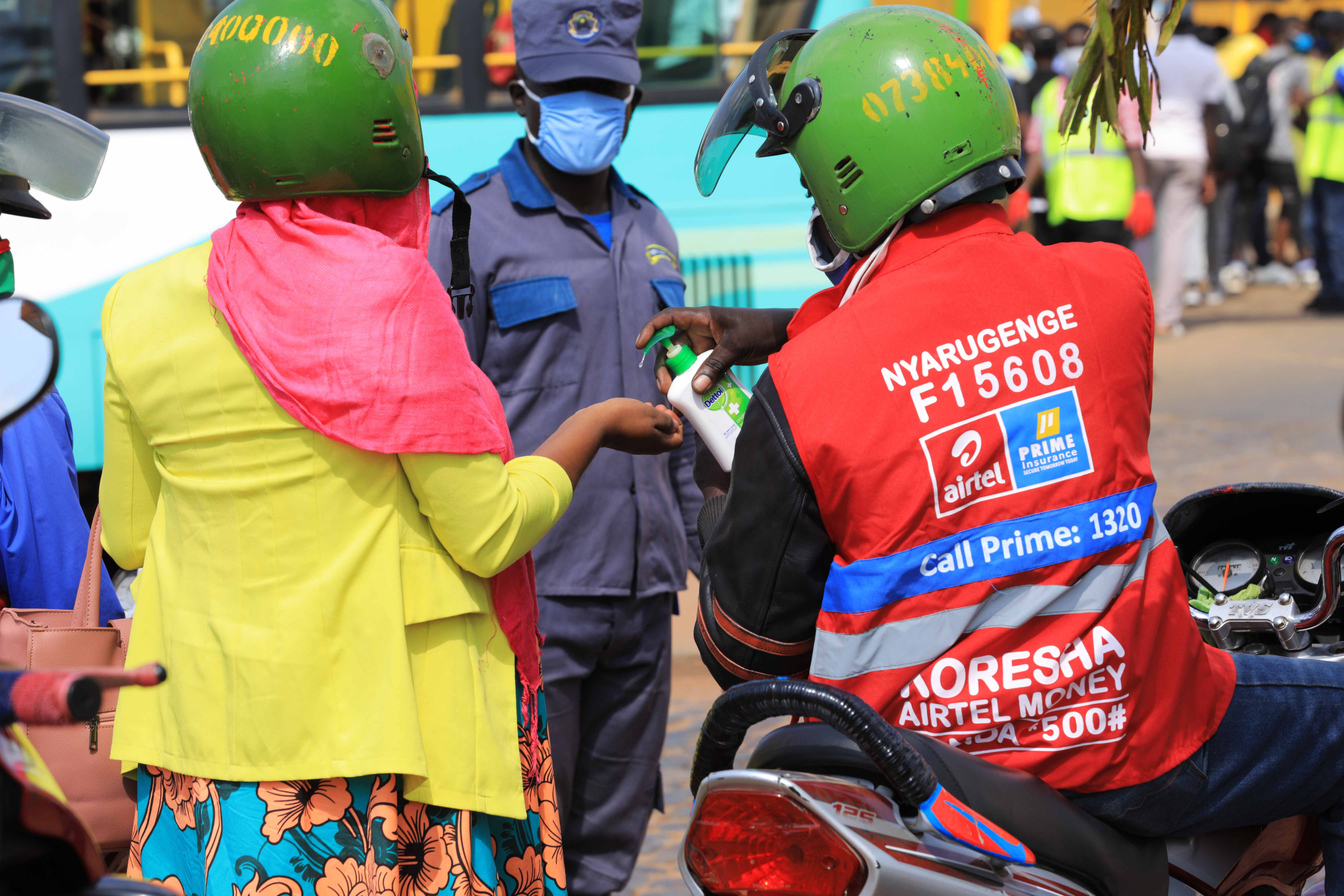 Taxis moto operator uses hand sanitizer for his client to comply with new regulations to fight the spread of Covid-19 in Kigali on 3 June 2020. 