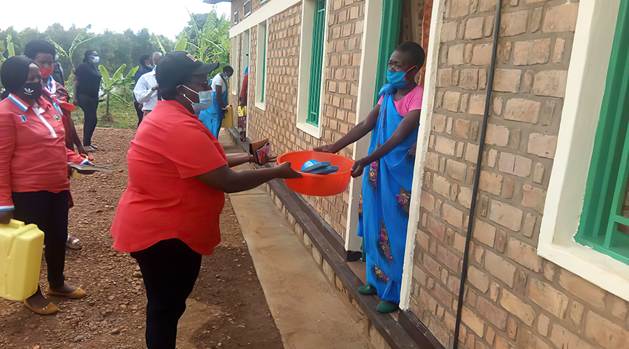RPF members hand over bars of soap and other items to a Genocide survivor in Muko Sector, Gicumbi District. 