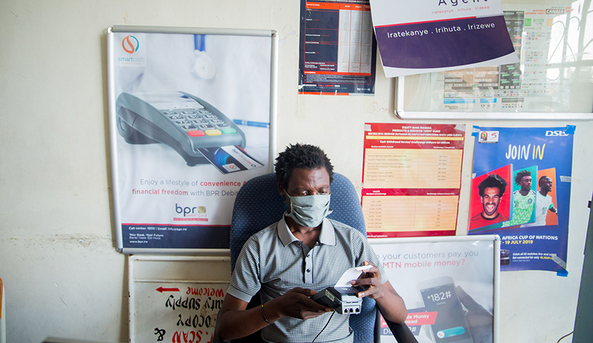 A BPR Hafi Agent at an outlet in Kigali.  BPR has over 300 agents providing  a range of services including cash deposit and withdrawal, sending and receiving money, paying taxes and balance inquiry among others. / Photo: Dan Nsengiyumva.