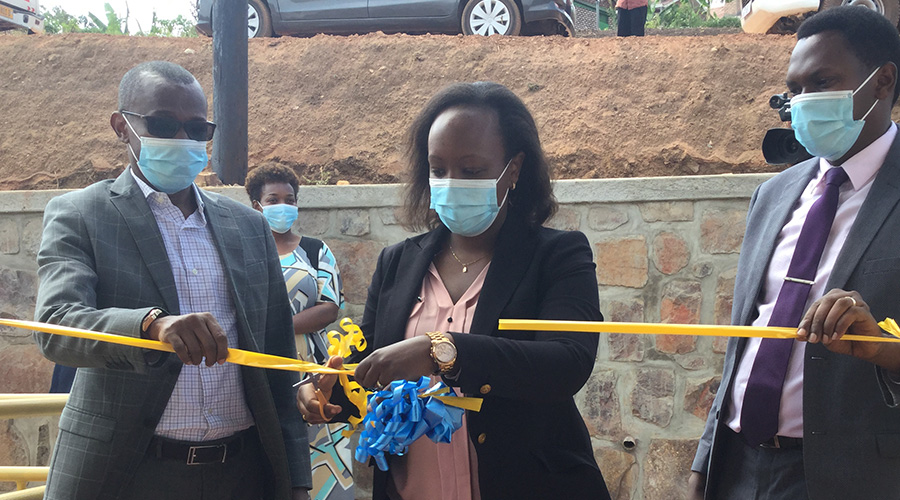 Umutoni, Vice Mayor in the City of Kigali (C) cuts the ribbon to inaugurate Rwf228 million house for the needy along with Jean-Marie Gacandaga, DDG at RSSB (L), and Emmy Ngabonziza, Executive Secretary at Nyarugenge.