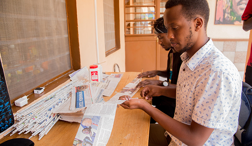 The artist and his colleague preparing recycled paper. / Photos by Dan Nsengiyumva