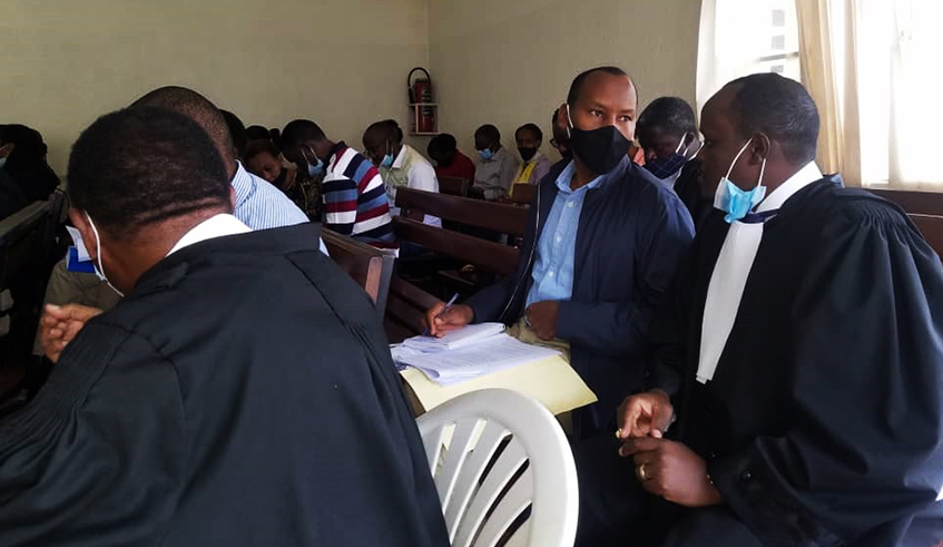 Rwamuganza consults with his lawyer  Moise Nkundabarashi at Gasabo Primary Court in June . / Courtesy