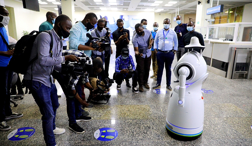 Journalists on a guided tour of the Kigali International Airport on Friday swarm around a temperature-taking robot, â€˜Urumuriâ€™, which has been deployed at the airport ahead of resumption of passenger flights on August 1. Officials at the national carrier, RwandAir, say they are confident demand for air travel will gradually pick up as more and more countries lift travel restrictions caused by the Covid-19 pandemic. / Photo: Sam Ngendahimana