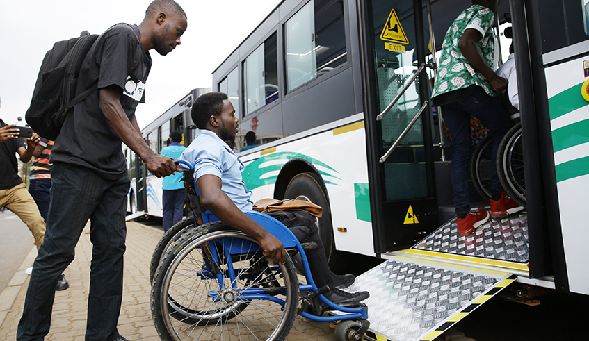 A man helps a person with disability board a bus at Kacyiru Bus Stop on August 30, 2019. / Photo: Sam Ngendahimana.