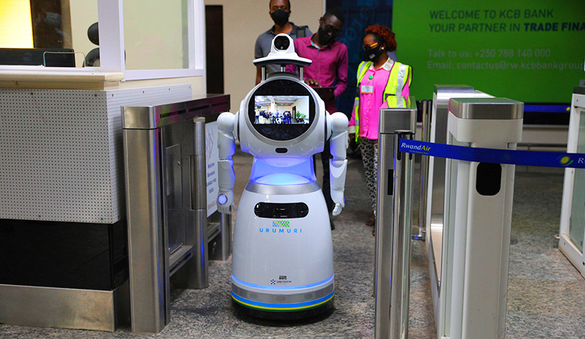 Journalists on a guided tour of the Kigali International Airport on Friday, July 17, are seen behind a temperature-taking robot, u2018Urumuriu2019, which has been deployed at the airport ahead of resumption of passenger flights on August 1. International passengers arriving at the airport from across the world must have taken and confirmed negative of Covid-19 test within not more than 72 hours of their departure, according to the latest guidelines from the Rwanda Biomedical Centre. / Photo: Sam Ngendahimana. 