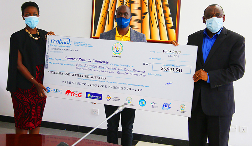 Minister of Infrastructure Claver Gatete hands over a cheque worth Rwf86.9 million to Minister of ICT and Innovation counterpart Paula Ingabire yesterday. / Craish Bahizi
