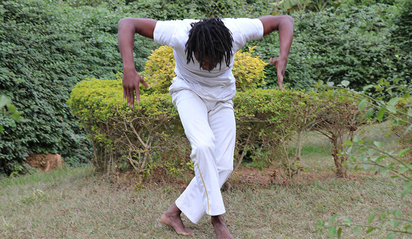 Abdoul Mujyambere rehearsing  in preparation for his performance  for the Africalia project at his studio  garden in Nyamirambo, Kigali.  