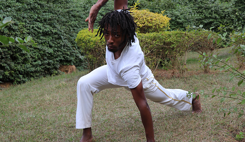 Abdoul Mujyambere rehearsing  in preparation for his performance  for the Africalia project at his studio  garden in Nyamirambo, Kigali.  