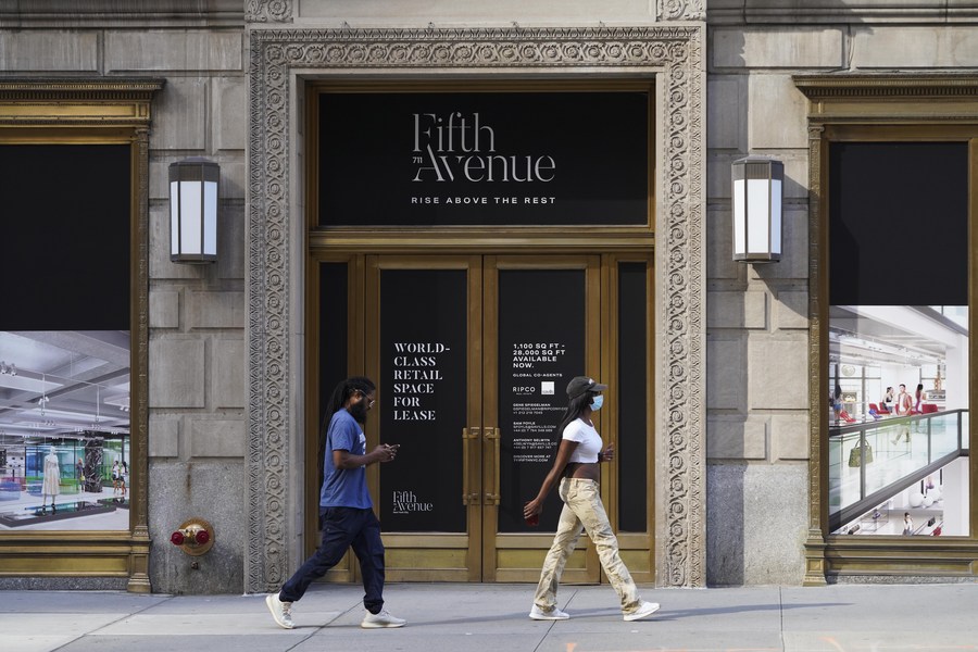 Pedestrians walk past a store for lease in New York, the United States, Sept. 4, 2020. 
