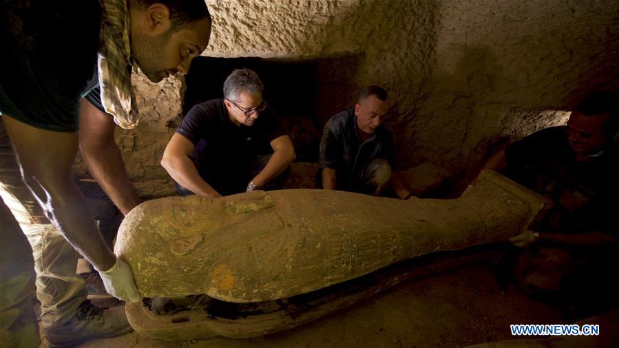 Egyptian Tourism and Antiquities Minister Khaled al-Anany (C) and Secretary General of the Supreme Council of Antiquities (SCA) Mostafa Waziri (R) look at a 2,500-year-old coffin discovered in Giza, Egypt, on Sept. 6, 2020. Egypt announced on Sunday the discovery of a collection of more than 13 intact sealed coffins dating back to 2,500 years ago. 