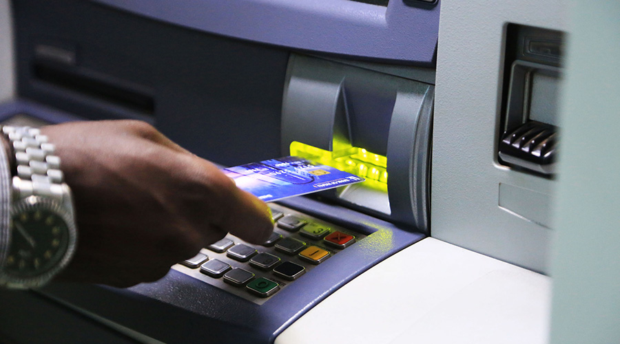 A client withdraws money from an ATM in Kigali. Local banks are reducing the number of ATMs across the country with some opting to roll out agency banking. 