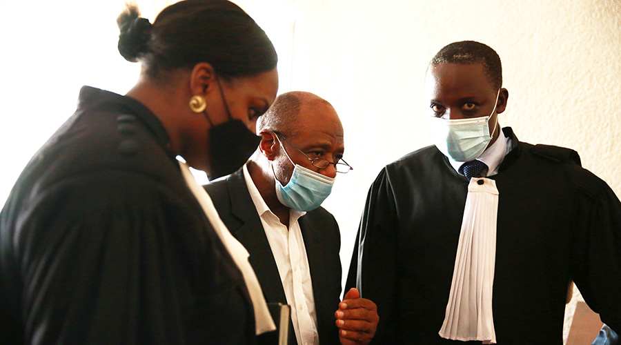 Rusesabagina interacts with his lawyers, David Rugaza and Emelyne Nyumbo  at Kicukiro Primary Court today. 
