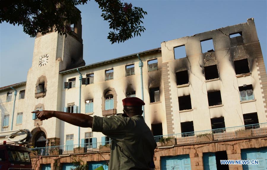 A security guard monitors the dilapidated administration building block of Makerere University, Kampala, Uganda, Sept. 20, 2020. An early morning major fire gutted Makerere University, Uganda's top university on Sunday, destroying the main administration building block, a police spokesperson said. 