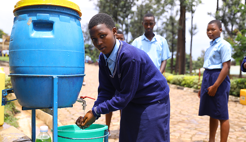 Students wash their hands before entering the class at G.S Rugando in Kigali in March . / Sam Ngendahimana
