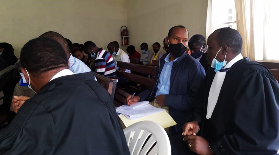 Former Permanent Secretary in the Finance ministry, Caleb Rwamuganza consults with his lawyer Moise Nkundabarashi in Gasabo Primary Court in June. 