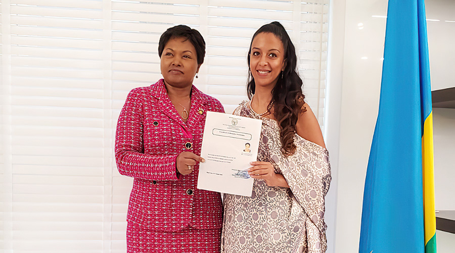 Amb. Mathilde Mukantabana, Rwandau2019s envoy to the United States of America (left), hands a certificate of citizenship to Setti Solomon in Washington on September 25. The Directorate of Immigration and Emigration has granted nationality to 935 foreign nationals from 2009 to date. 
