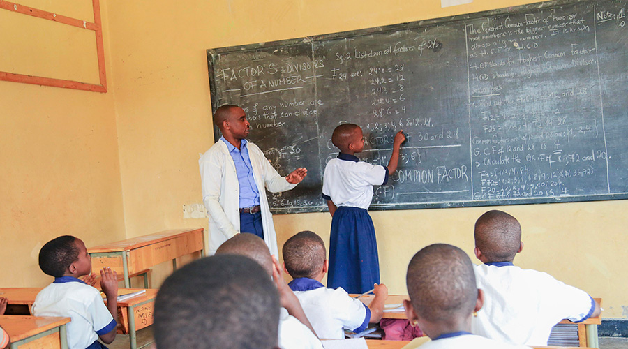SOS teacher inspects how his students do exercise in Kigali. 