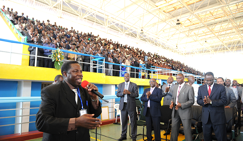 Pastor Canisius Nzabonimpa leads members of ADEPR in praise and worship songs as they meet President Kagame at Amahoro Stadium in Kigali in December 2012. / Photo: File.