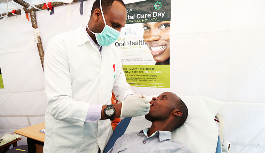 Dr Tecian Musafiri checks up a patient during a campain to promote oral health at King Faisal Hospital in 2018. The new policy on duo practice allows healthcare practitioners to practice in more than one place of work u2013 public or private. / Photo: Sam Ngendahimana. 