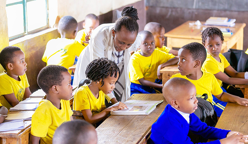 A teacher helps pupils during class at Groupe Scolaire Camp Kigali. / Photo: File.