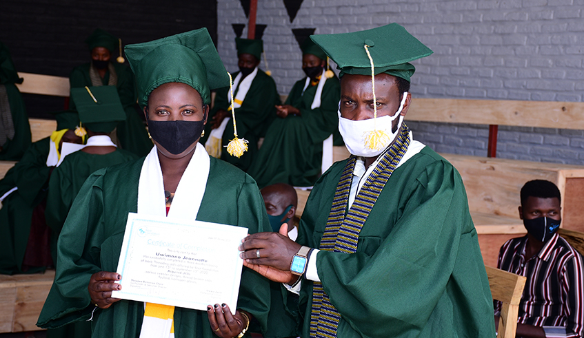 One of the beneficiaries (left) is handed her certificate during the graduation ceremony. / Photo: Courtesy