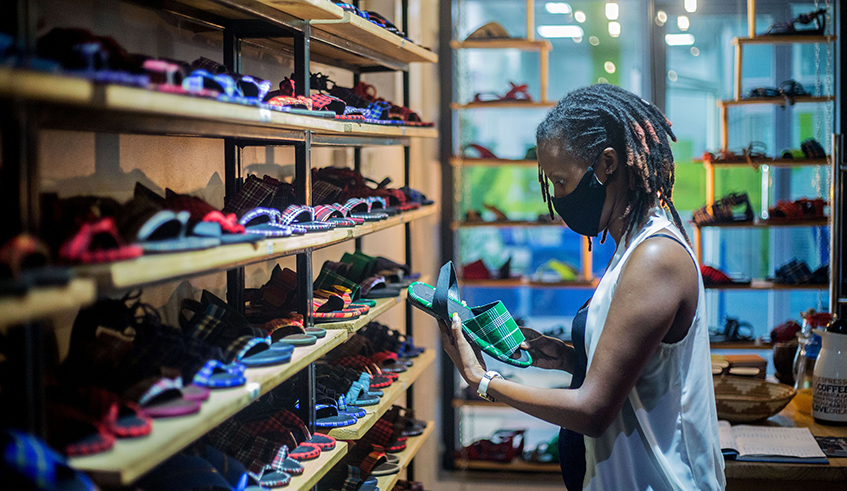 A customer admires some of the sandals made by local fashion house UZURI K&Y at their outlet at Kigali Heights on November 3, 2020. The firm has recently been at the centre of a patent infringement dispute after a pair of their sandals appeared on an advertisement page of another company. / Photo: Dan Nsengiyumva.