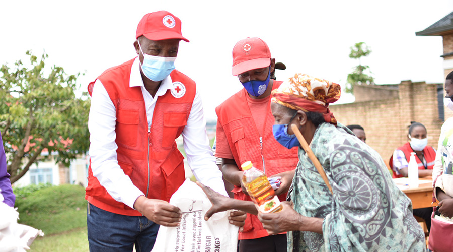 Pierre-Claver Ndimbati, Head of Programmes at Rwanda Red Cross, hands foodstuffs to a beneficiary of its support during an event in Muhanga District, on Friday, November 6, 2020. 