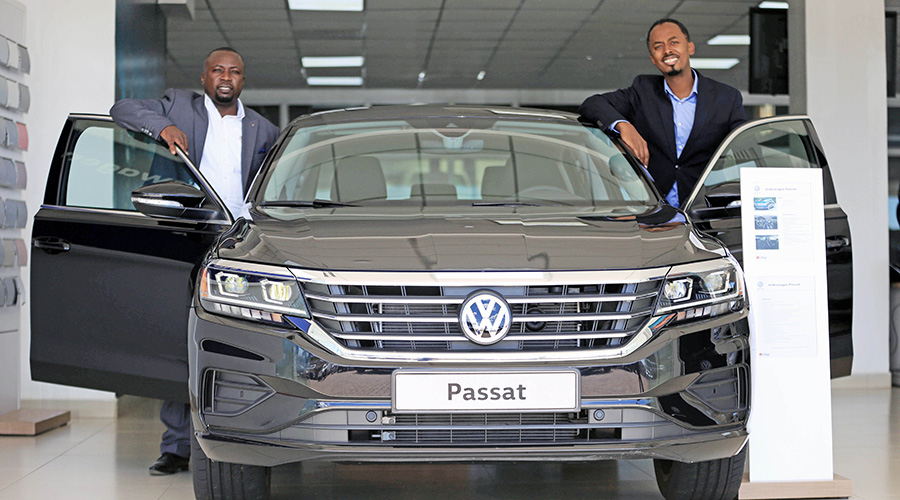 Serge Kamuhinda (right), CEO of Volkswagen Mobility Solutions Rwanda, and Levy Ouso, the firmu2019s General Manager of the retail market, pose for a photo on Volkswagenu2019s new brand Passat. 
