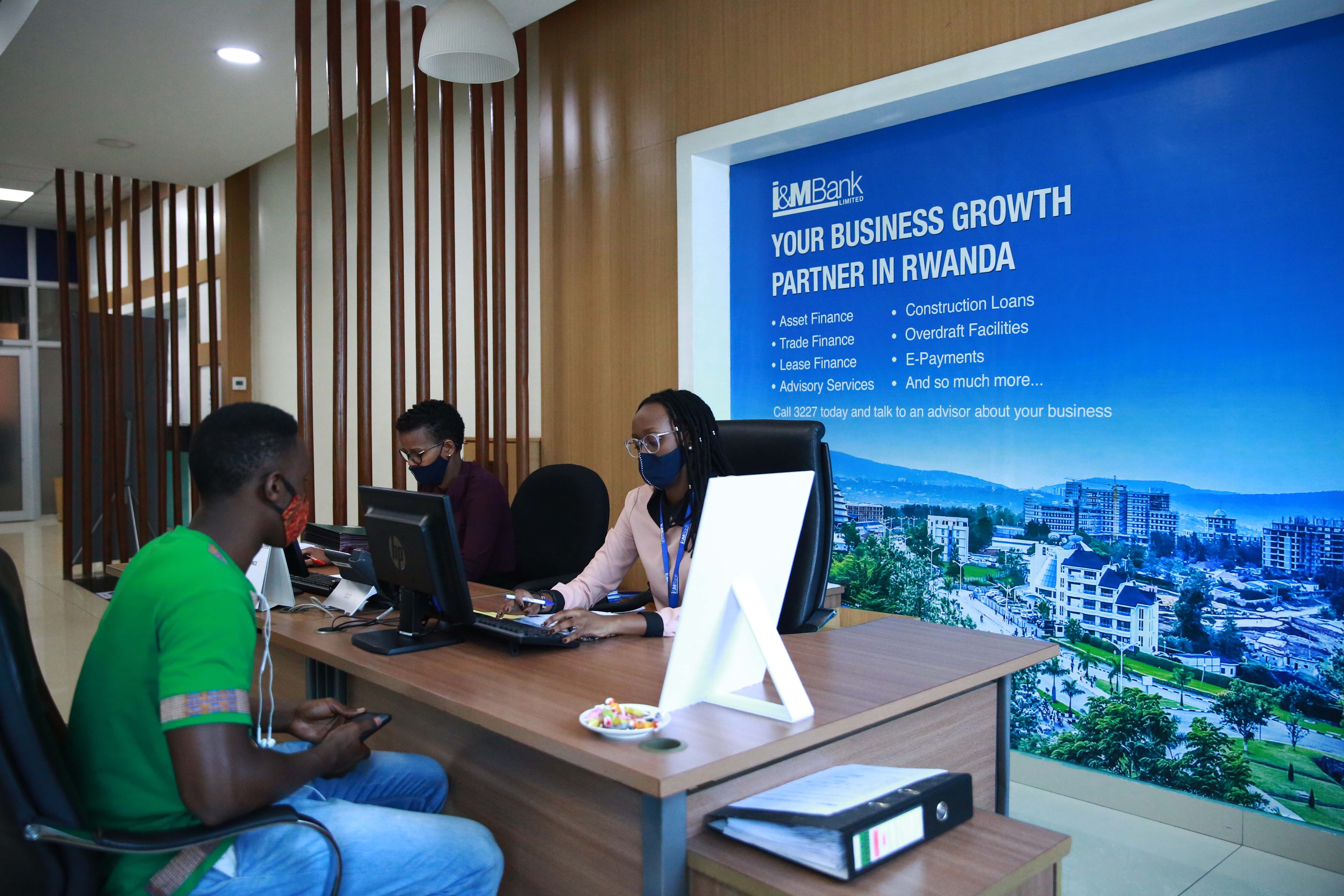 I&M Bank client interacts with information desk personnel at Kigali Heights branch in July. 