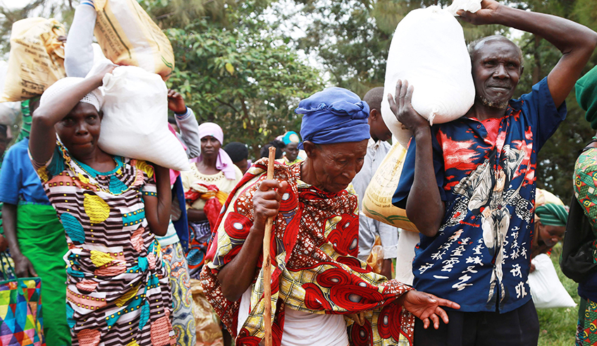 Residents who belong to Ubudehe Category E carry foodstuff at Jali sector in Gasabo District last year. / Photo: Sam Ngendahimana.