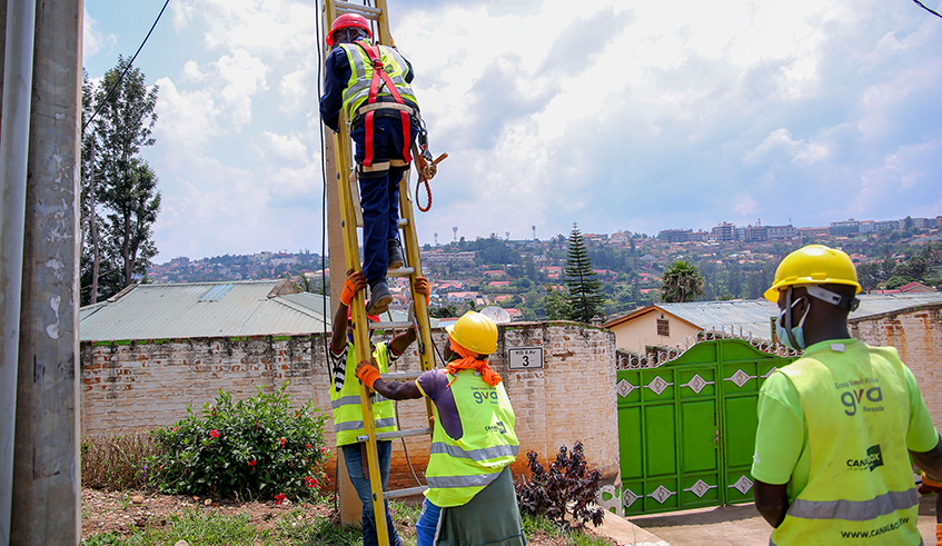 CanalBox Rwanda technicians install aerial fibre optic cables in a Kigali neighbourhood fiber on June 22. / Photo: Dan Nsengiyumva.