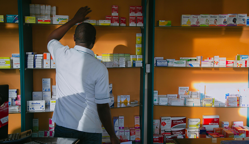 A pharmacist searches for drugs on a shelf in Kigali on May 13, 2019. / Photo: File.