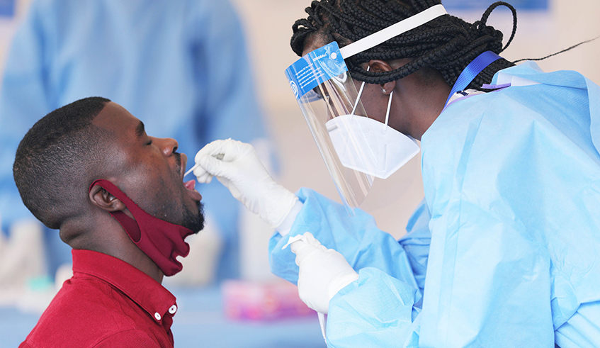A health worker tests a man for Covid-19 in Kigali recently. / Photo: File.